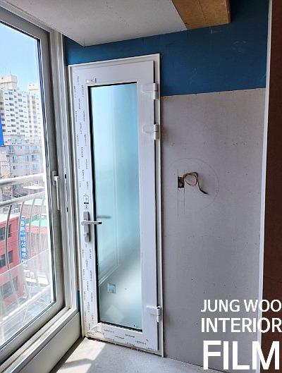 유리 패널 도어와 전선이 노출된 발코니 공간