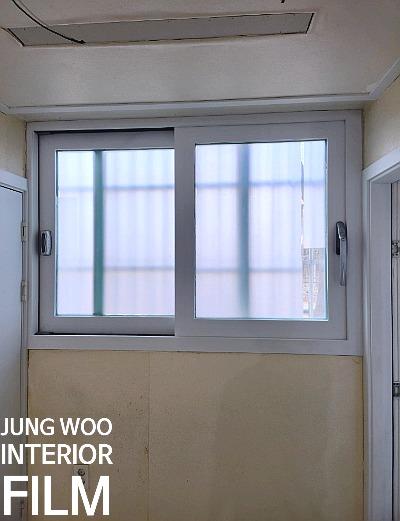 창가 쪽 프레임에 필름을 부착하는 모습