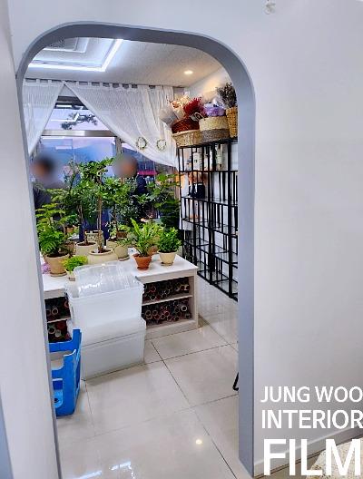 흰색 커튼과 식물 테이블이 있는 창가 공간