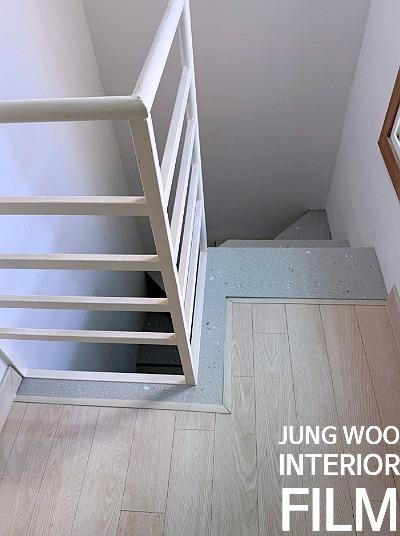 흰색 난간이 설치된 계단 옆 복도 전경