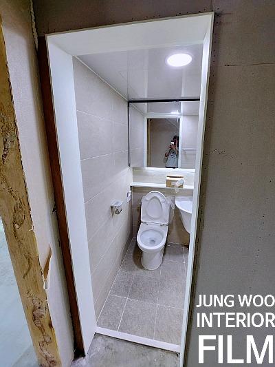 양변기와 거울이 보이는 욕실 내부 모습