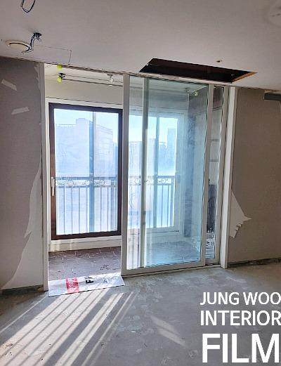슬라이딩 도어와 창문이 설치된 공사 중인 공간