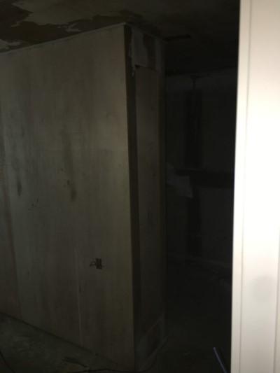 벽면이 노출된 상태의 어두운 실내 공간