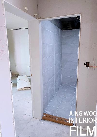 전기 소켓이 설치된 벽면과 회색 타일 바닥