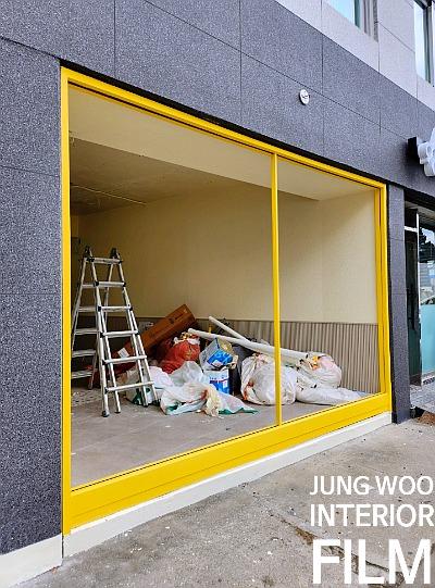 노란색 프레임 창문과 콘크리트 바닥의 실내 전경