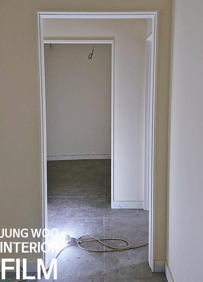 회색 타일 바닥과 흰색 문틀이 있는 복도