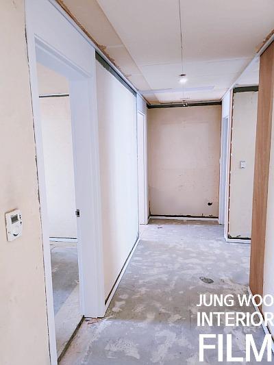 흰색 도어가 설치되고 있는 복도 전경