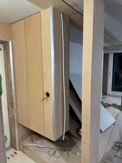 수납장과 우드톤 바닥이 만나는 지점의 작업 모습