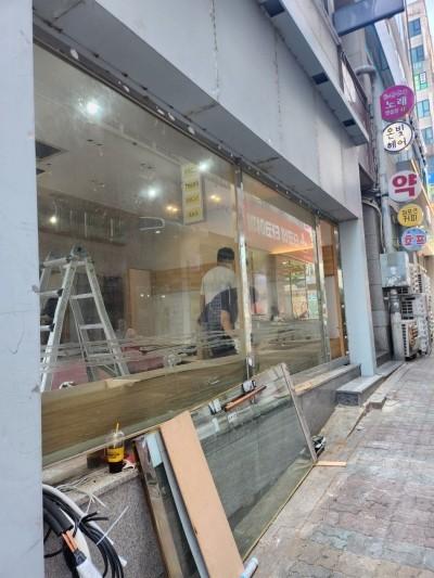 철제 사다리와 유리판이 놓인 실내 유리창 작업 현장