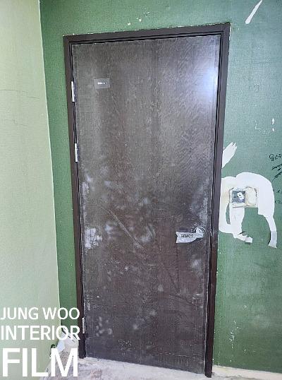 녹색 벽면과 어두운 색상 도어가 설치된 모습