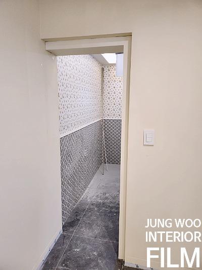 점무늬 벽지와 회색 타일이 설치된 복도 면