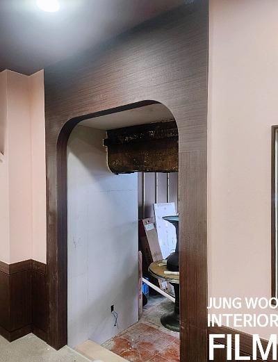 갈색 패널이 적용된 아치형 문틀과 붉은 타일 바닥