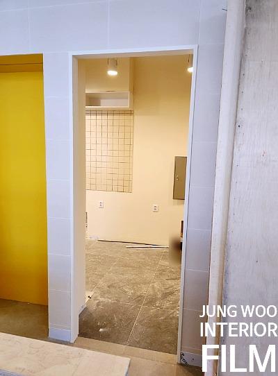 격자형 타일과 흰 벽돌 벽이 교차하는 문 주변