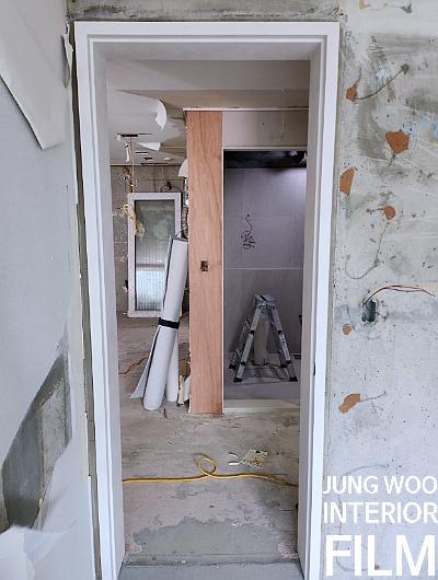 콘크리트 벽면과 나무 보강재가 보이는 문틀 주변