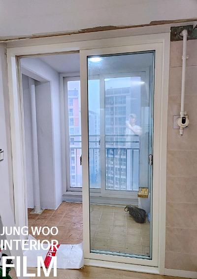 슬라이딩 유리문 너머로 보이는 발코니 타일 바닥