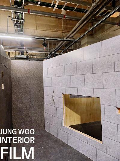 노출 배관과 어두운 타일 바닥, 목재 구조물이 보이는 공간
