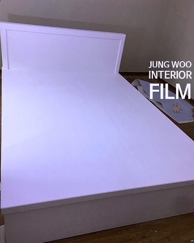 화이트 필름으로 마감된 침대 프레임이 놓인 방