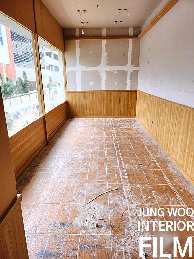 흰색 테이프 마감과 목재 패널이 적용된 타일 바닥 공간