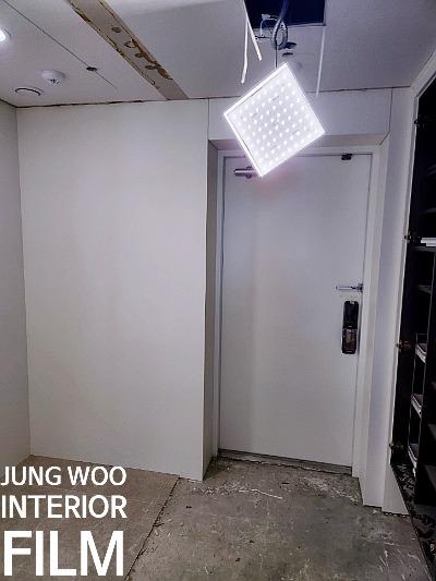 천장 구조물과 흰색 문이 있는 실내 작업 모습