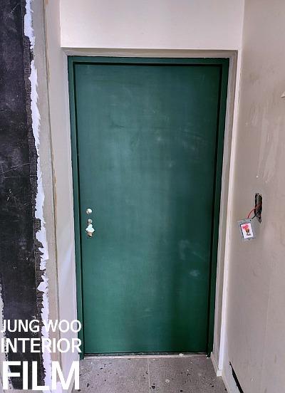 녹색 도어가 설치된 복도와 콘크리트 바닥
