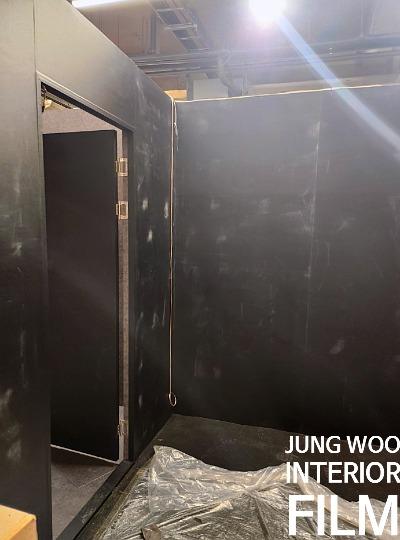 검은색 벽면과 도어가 설치된 공사 중인 실내