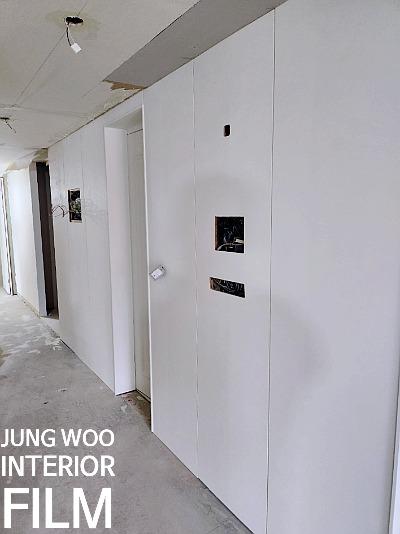 흰색 벽면의 마감이 진행 중인 복도 공간