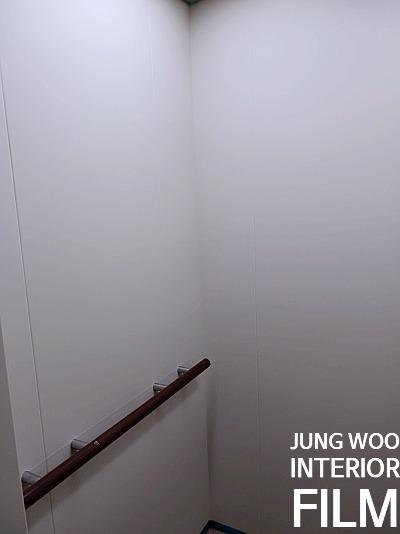 흰 벽면을 따라 설치된 나무 손잡이 구간