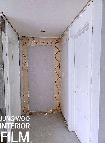 벽면 구멍과 도어가 설치된 시공 전 복도