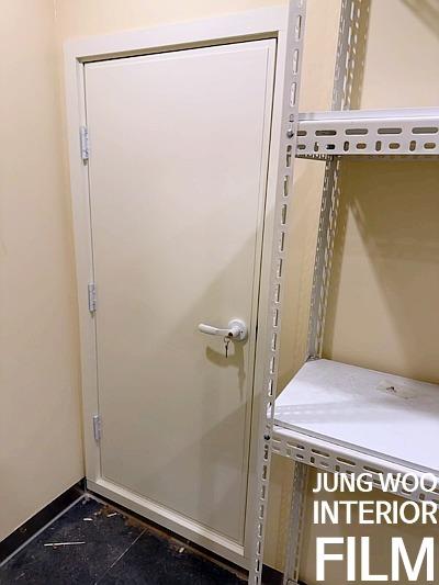 흰색 도어와 금속 선반이 놓인 실내 공간
