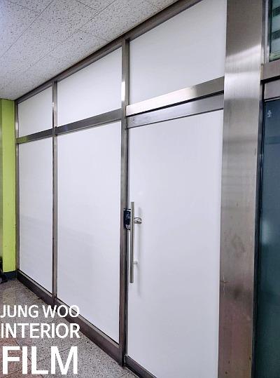 점박이 패턴 석재 천장과 흰색 도어가 있는 복도