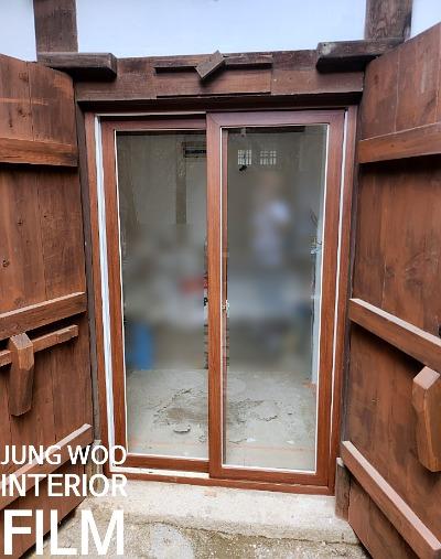 공사 중인 상태의 목재 구조물과 유리 문