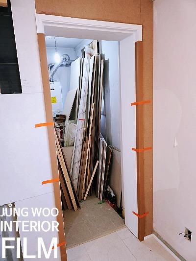 목재 자재와 보드가 쌓여 있는 실내 작업 공간