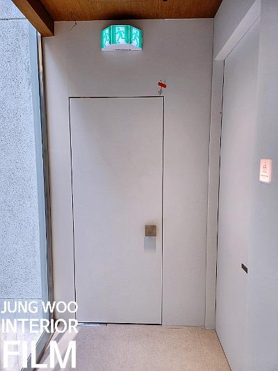 출구 표시등과 석재 벽면이 보이는 복도