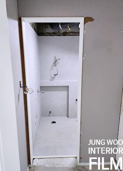 배관과 전선이 노출된 흰 벽면 공간