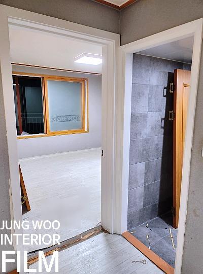 목재 창호 프레임과 회색 타일 벽면의 경계