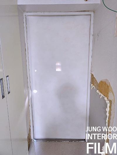흰색 도어가 있는 복도와 벽지가 벗겨진 벽면