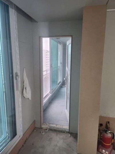 흰색 페인트 벽면과 흙바닥이 보이는 복도 전경