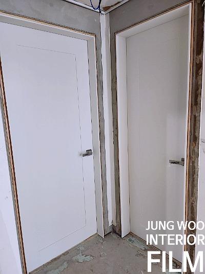 회색 벽면과 두 개의 흰색 문이 있는 복도