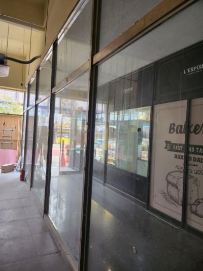 검은색 프레임 유리문과 Baker 포스터가 있는 통로