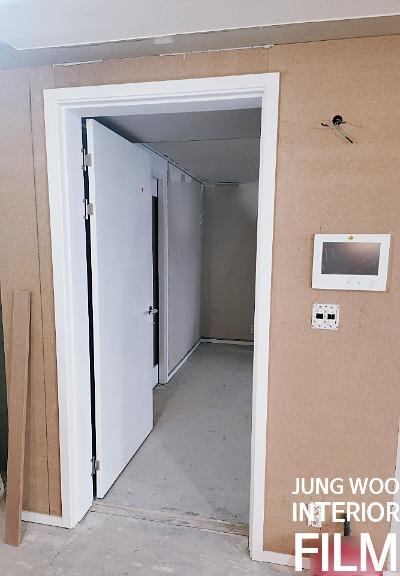 베이킹 보드 벽면과 흰색 문이 있는 복도
