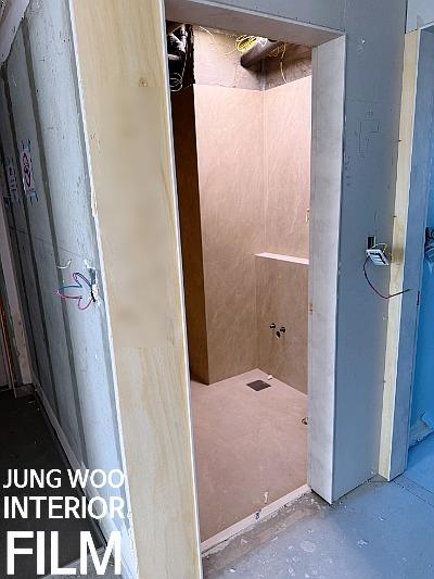보드로 마감된 복도와 노출된 문틀 전선