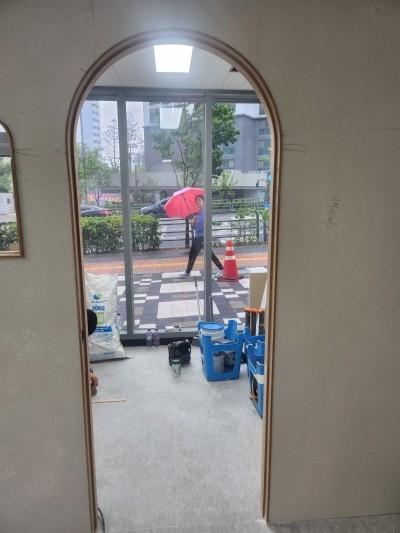 아치형 문 너머로 보이는 타일 바닥의 내부 공간