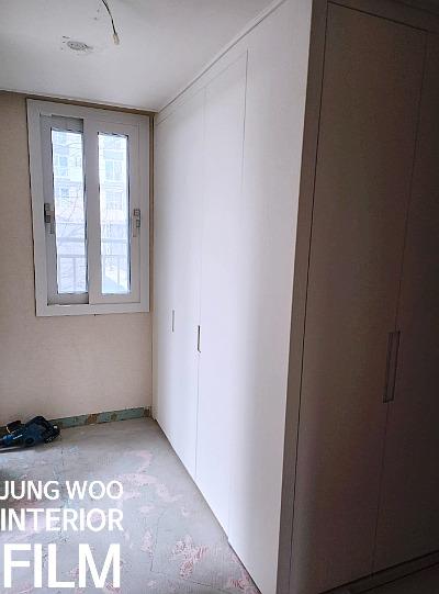 흰색 수납장과 창호가 있는 드레스룸 공사 중 모습