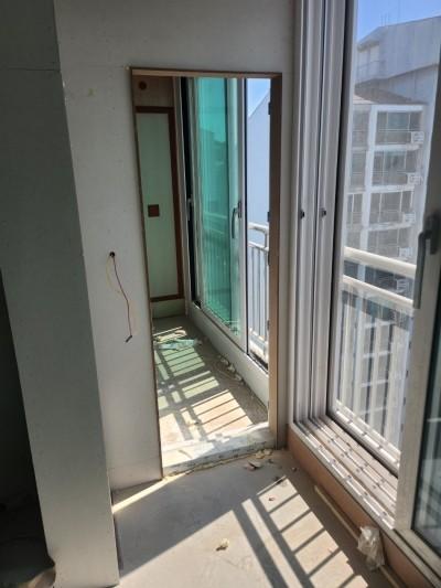 흰색 타일 바닥과 노출 전선이 보이는 발코니 벽면