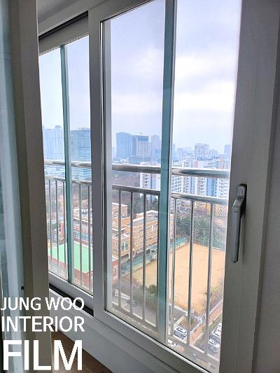 화이트 창호 너머로 도시 풍경이 보이는 모습