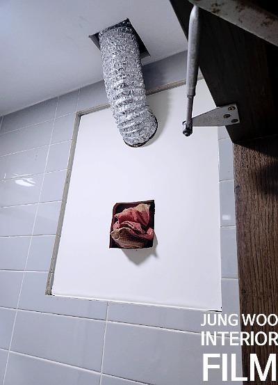 흰색 패널 위 금속 호스와 나무 구조물