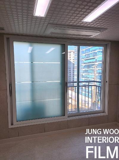 베이지색 타일 벽면과 흰색 프레임의 슬라이딩 창호