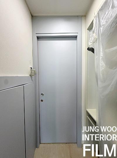 회색 도어와 수납장이 설치된 복도 벽면