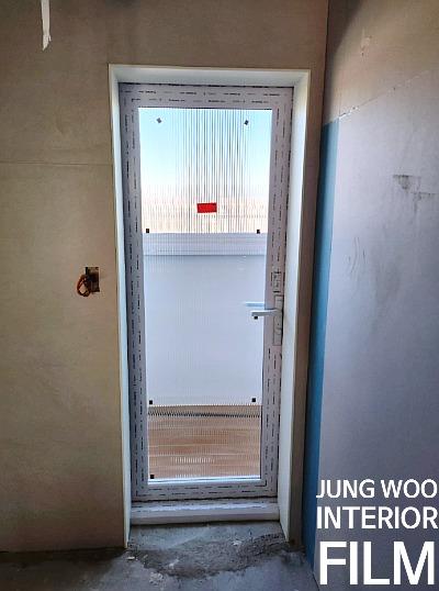 도어 유리 패널과 프레임이 보이는 현관