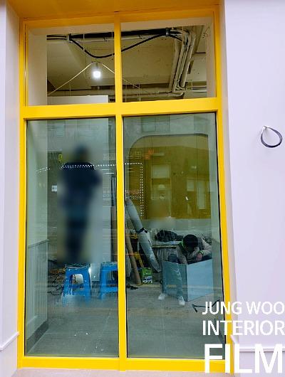 작업 도구들이 놓인 노란 테두리 유리창 공간